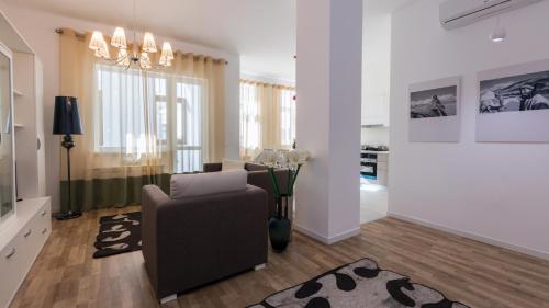 a living room with a couch and a chair at The Arc Residence in Astana