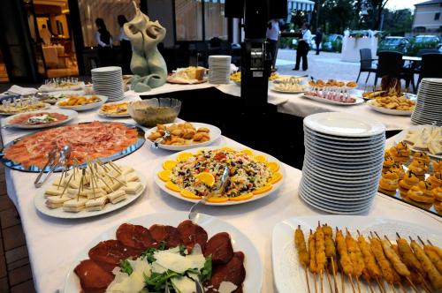a table with many plates of food on it at Hotel La Torretta in Castel San Pietro Terme