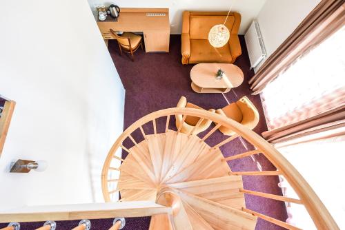 an overhead view of a spiral staircase with chairs and tables at Muza Hotel in Palanga