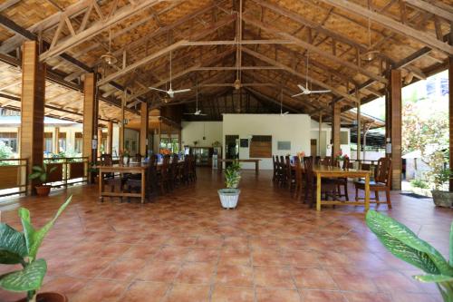 a large room with wooden ceilings and tables and chairs at Two Fish Resort Bunaken in Bunaken