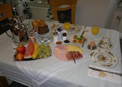 a table with a plate of food and fruit on it at Pension Mosellablick in Briedern