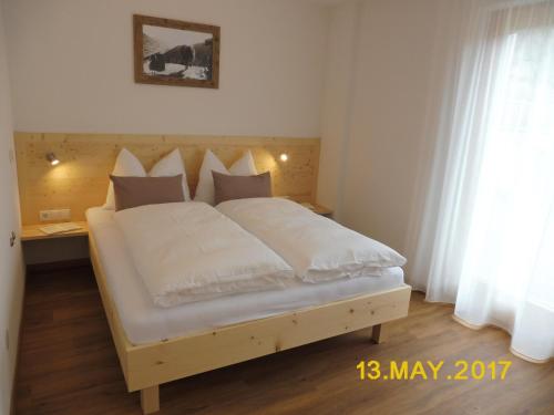 a bed with white sheets and pillows in a bedroom at Leitnerhof in Terento