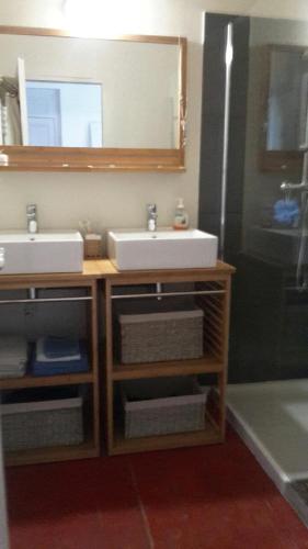 une salle de bain avec un lavabo et un miroir dans l'établissement DEMEURE 300m DE LA PLAGE, à Soulac-sur-Mer