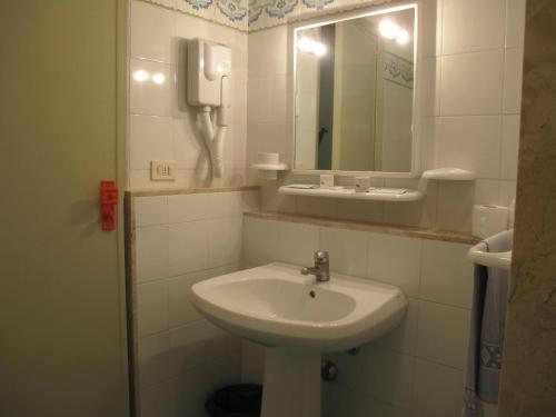 a bathroom with a sink and a mirror and a phone at Hotel Phenicusa in Filicudi