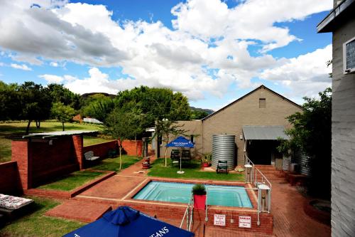 a backyard with a swimming pool and a house at Villa Paradiso in Hartbeespoort