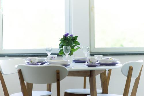 a dining room table with white chairs and a table with glasses at Amazing Penthouse old town in Sarajevo