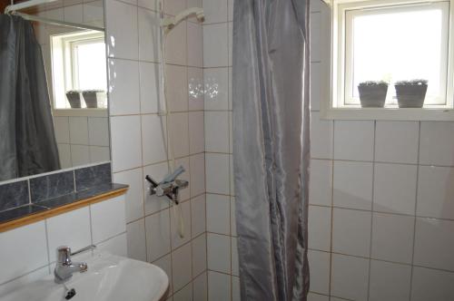 a bathroom with a shower with a sink and a mirror at Nordseter Fjellpark, Hyttegrend in Nordseter