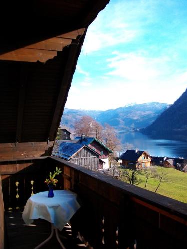 a table on a balcony with a view of a lake at Ferienwohnung Syen in Grundlsee