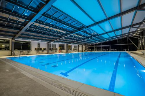 a large indoor swimming pool with blue lighting at Apollo Beach in Faliraki