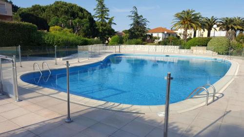 une grande piscine avec de l'eau bleue dans l'établissement Appartement Charmant Vélusine, à Antibes