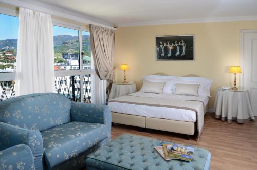 モンテカティーニ・テルメにあるAmbasciatori Palaceのベッドルーム1室(ベッド1台、椅子、ソファ付)