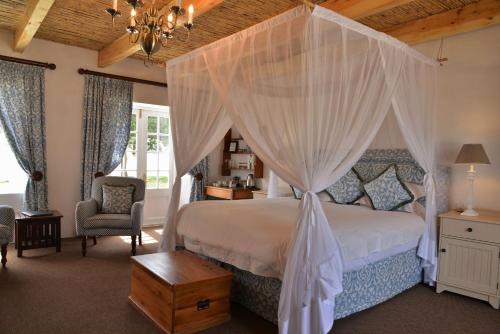 a bedroom with a bed with a canopy at De Hoop Collection Suites in De Hoop Nature Reserve