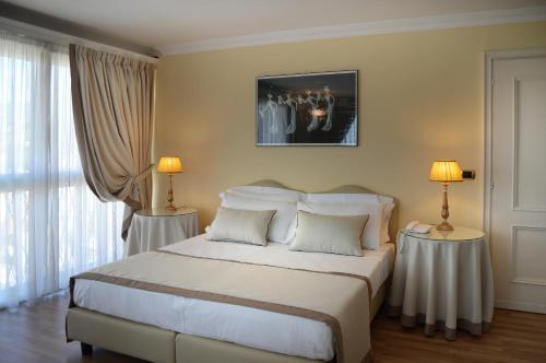 a bedroom with a large bed with two lamps at Ambasciatori Palace in Montecatini Terme