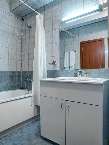 a bathroom with a sink and a tub and a shower at Flora Hotel - Apartments in Borovets
