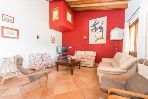 a living room with red walls and a couch and chairs at Vora Pula Golf II in Son Servera