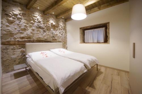 ティニャーレにあるAl Terrazzo Apartments - Ruculì Hospitalityの石造りの壁のドミトリールーム(ベッド1台)
