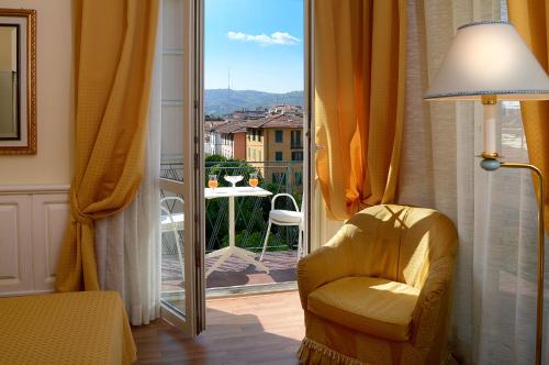 a room with a chair and a window with a view at Ambasciatori Palace in Montecatini Terme