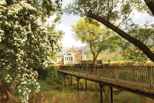 a house on a bridge over a river at Millbrook Resort in Arrowtown
