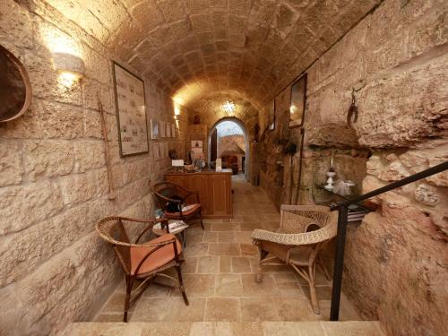 um corredor num edifício de pedra com cadeiras e mesas em Masseria Maccarone em Fasano
