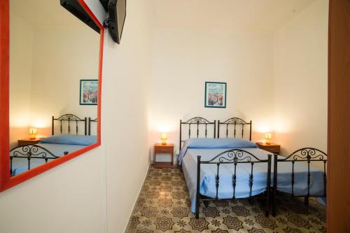 トラーパニにあるLargo Madonnaのベッドルーム1室(ベッド2台、鏡付)