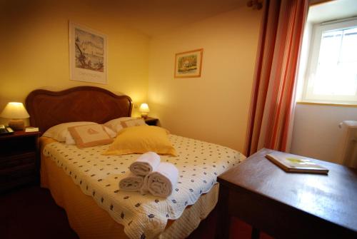 a bedroom with a bed with towels on it at Logis Cote Loire - Auberge Ligerienne in Blois