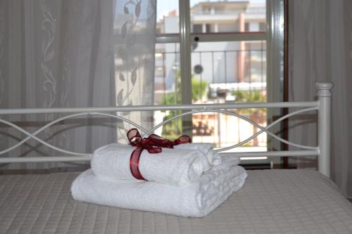 モノーポリにあるLa Casa Del Cuoreの窓付きのベッドにタオルを積み重ねます。