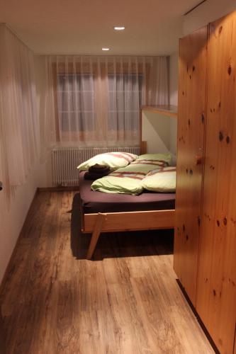 サースフェーにあるMier Gfallt`sのベッドルーム1室(ベッド1台付)、木製キャビネットが備わります。