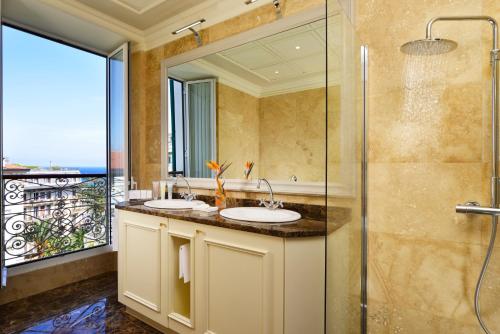 baño con 2 lavabos y ducha de cristal en Royal Hotel Sanremo, en San Remo