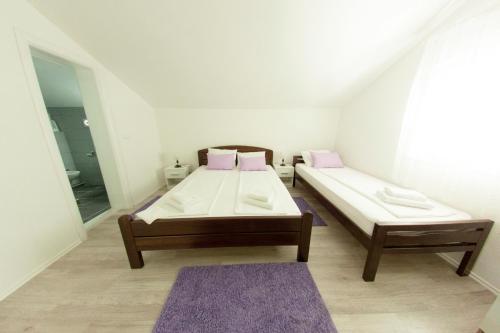 een slaapkamer met 2 bedden en een spiegel bij King San in Mostar