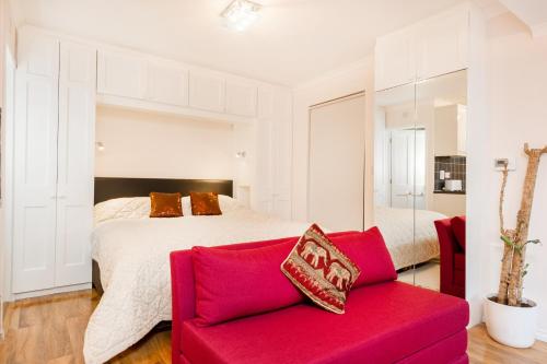 ヘンリー・オン・テムズにあるHenley-on-Thames Studio Apartmentのベッドルーム1室(ベッド1台、赤いソファ付)
