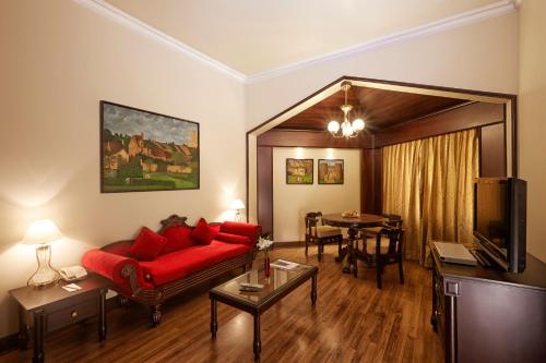a living room with a red couch and a dining room at The Gateway Hotel Beach Road, Calicut in Kozhikode