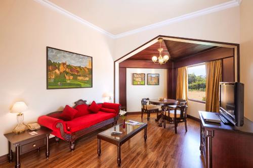 a living room with a red couch and a table at The Gateway Hotel Beach Road, Calicut in Kozhikode