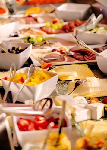 einem Tisch voller Teller und Schüsseln in der Unterkunft LIFESTYLE Resort Zum Kurfürsten in Bernkastel-Kues