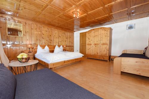 1 Schlafzimmer mit 2 Betten in einem Zimmer mit Holzwänden in der Unterkunft Haus Brügga in Brand