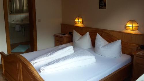 a bedroom with a white bed with two pillows at Pension Schwemberger ohne Frühstück in Mayrhofen