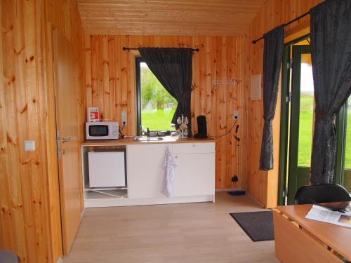 a kitchen with a sink and a microwave at Miðhvammur Farm Stay in Aðaldalur