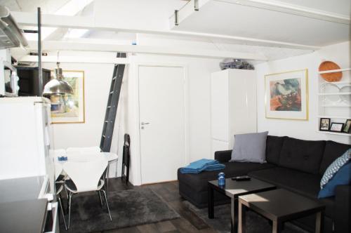 sala de estar con sofá negro y mesa en Aarhus bugtens Perle en Malling