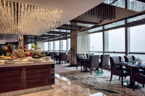 a restaurant with tables and chairs and chandeliers at Minyoun Chengdu Dongda Hotel in Chengdu