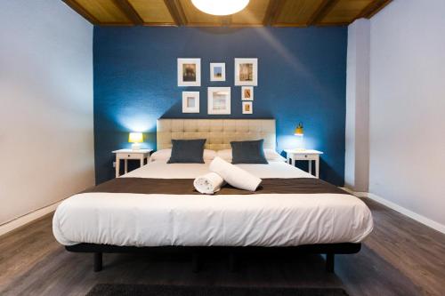 une chambre avec un grand lit aux murs bleus dans l'établissement Total Valencia Vintage, à Valence