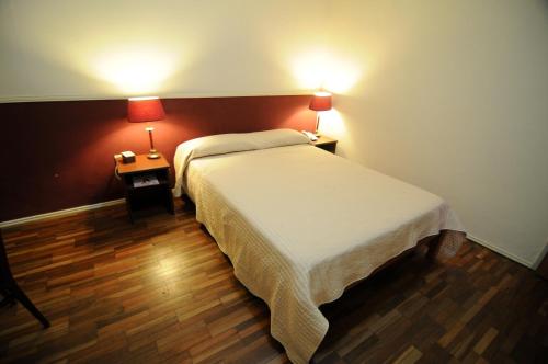 a bedroom with a bed and two lamps on two tables at Gran Hotel Uruguay in Salto