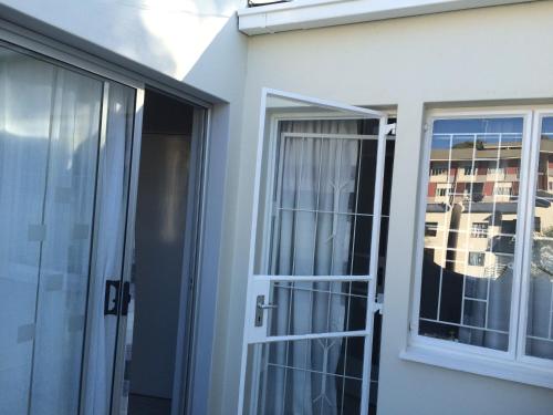 uma porta de vidro deslizante numa casa com uma varanda em Damara Gardens em Windhoek