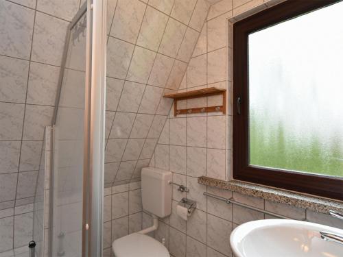 a bathroom with a toilet and a sink and a window at Finnhütte Carolin in Gager