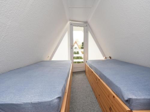 two beds in a small room with a window at Finnhütte Carolin in Gager