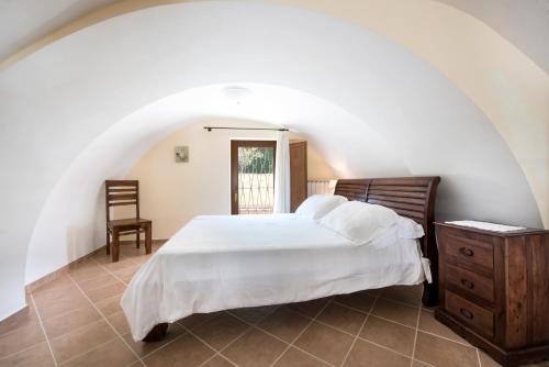 1 dormitorio con cama blanca y tocador de madera en Casale Le Noci, en Vico Equense
