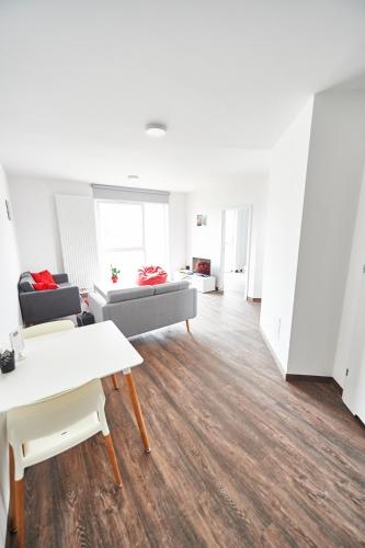 a living room with white walls and wooden floors at Cube Apartamenty in Lublin