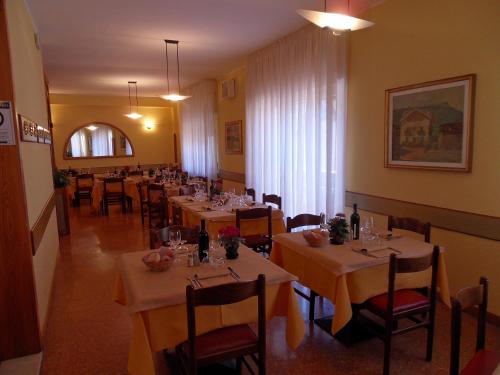 a restaurant with tables and chairs in a room at Albergo Betulla in Onore