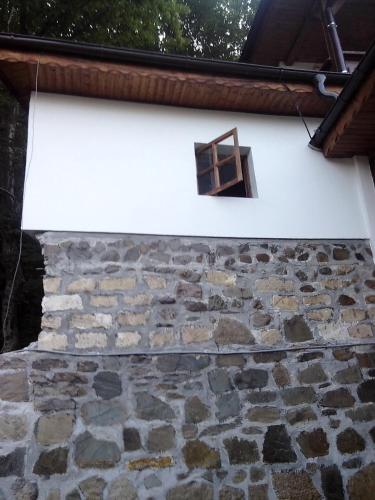 a window on the side of a stone wall at Casa cu Turn in Sărata-Monteoru