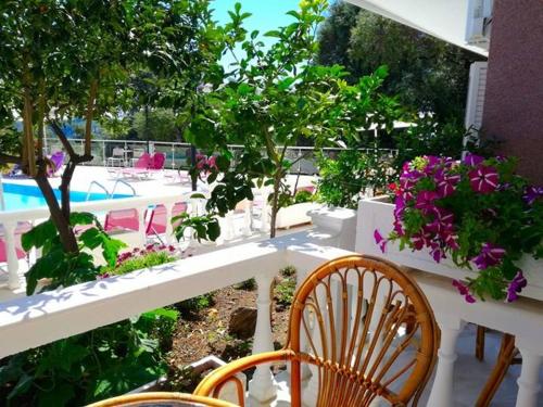a patio with tables and chairs and purple flowers at Kanali Studios in Parga