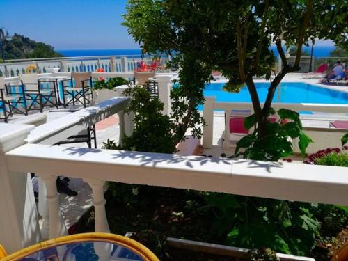 a view of a swimming pool with tables and chairs at Kanali Studios in Parga