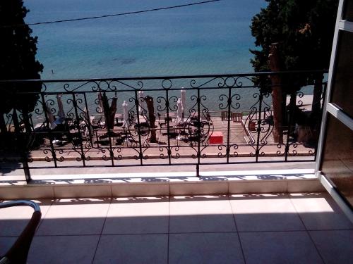 a balcony with a view of a beach and the ocean at Hotel Romantica in Loutra Edipsou